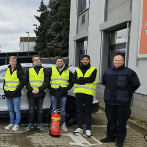 Andre Leiber mit Teilnehmern einer Brandschutzhelfer-Ausbildung in Sicherheitswesten.